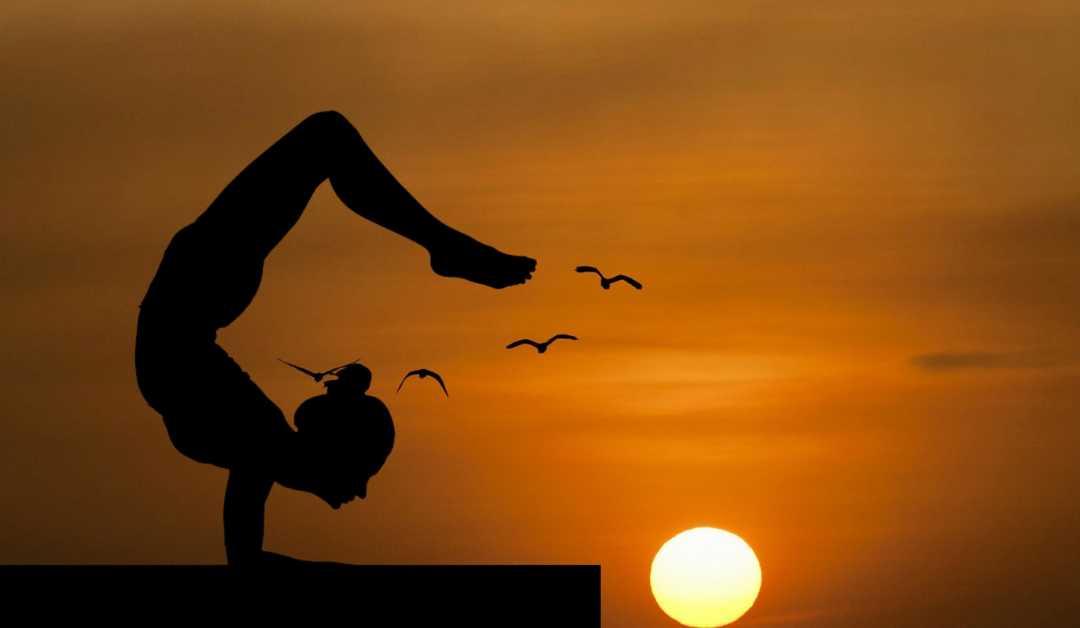 Best Yoga Poses for Hair Growth Holpura feature scorpion pose with sunset backdrop