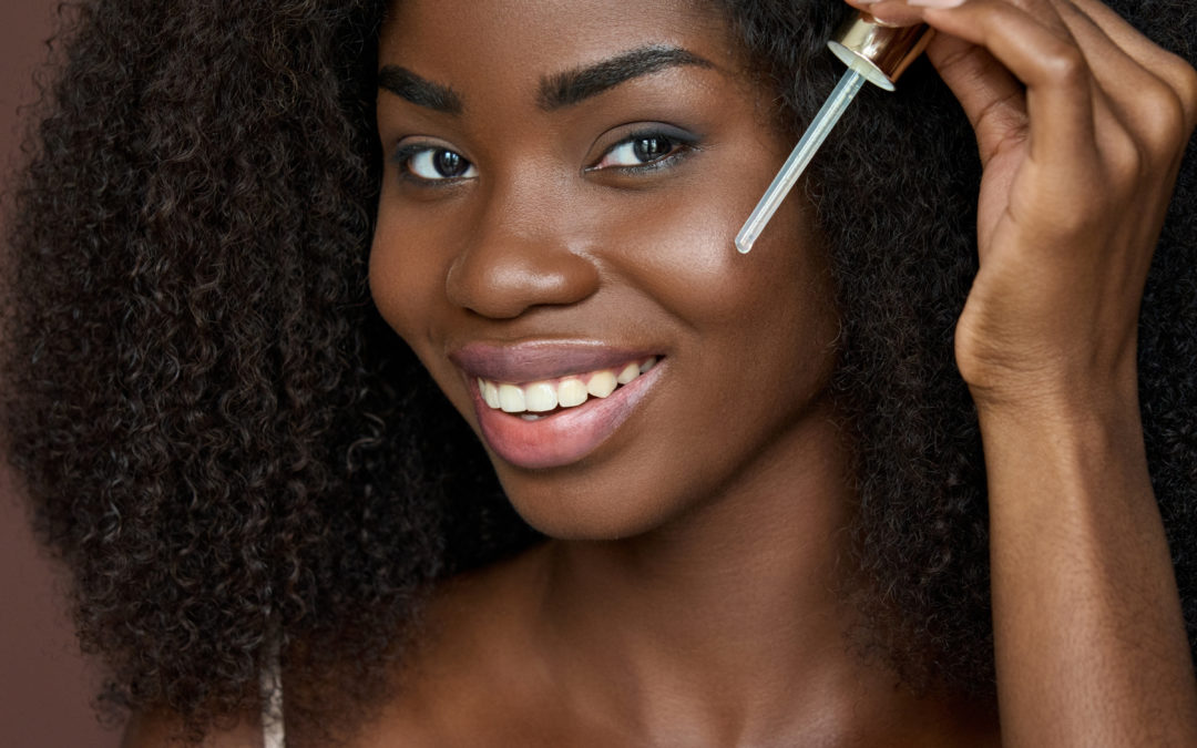 Beautiful african woman applying facial oil to skin holpura blog image